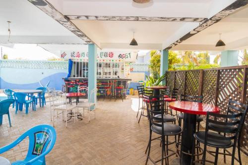 a restaurant with tables and chairs and a bar at Pidows studio apartment in Shanzu