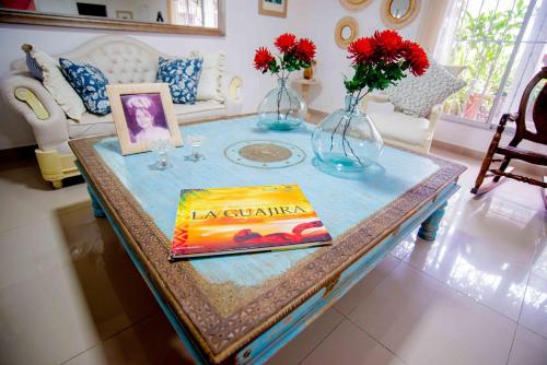 a living room with a table with a book on it at Casa Nora Alojamiento Entero, 4 Habitaciones Capacidad Máxima 9 huéspedes in Ríohacha