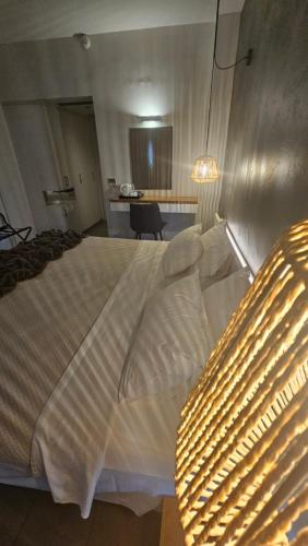 a bedroom with a large white bed with a light at Atlantis Boutique City Hotel in Rhodes Town