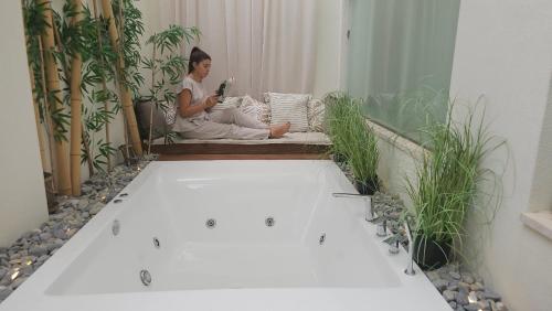 a woman sitting on a couch in a room with plants at Atlantis Boutique City Hotel in Rhodes Town