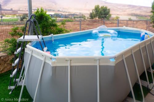 a hot tub on a porch with a ladder around it at יפעת הגלבוע -סוויטות אירוח ברמה אחרת in Nurit