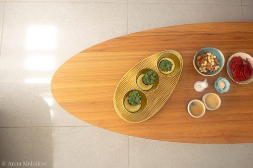 a wooden table with bowls of food on it at יפעת הגלבוע -סוויטות אירוח ברמה אחרת in Nurit