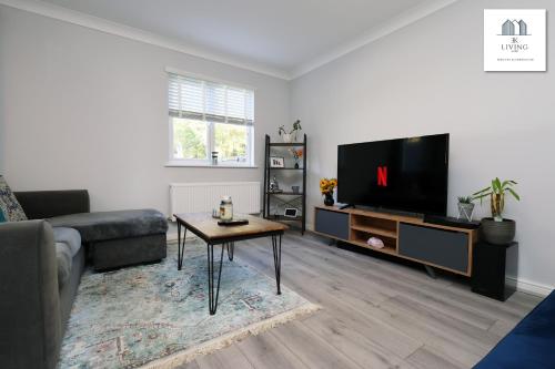 a living room with a couch and a tv at Spacious 3 Bed Home In The Heart Of Bridgend - By EKLIVING LUXE Short Lets & Serviced Accommodation in Bridgend