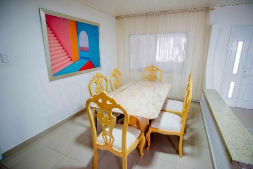a dining room with a table and chairs and a painting at Casa Nora Alojamiento Entero, 4 Habitaciones Capacidad Máxima 9 huéspedes in Ríohacha