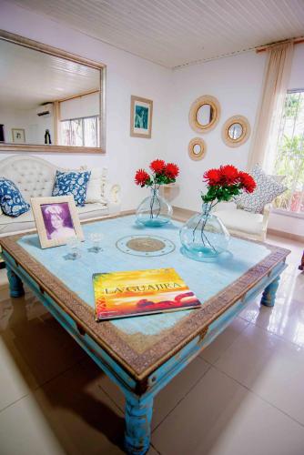 a living room with a table with flowers on it at Casa Nora Alojamiento Entero, 4 Habitaciones Capacidad Máxima 9 huéspedes in Ríohacha