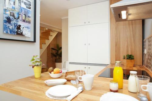 a kitchen with a wooden table with plates and drinks at Flores Guest House in Lisbon