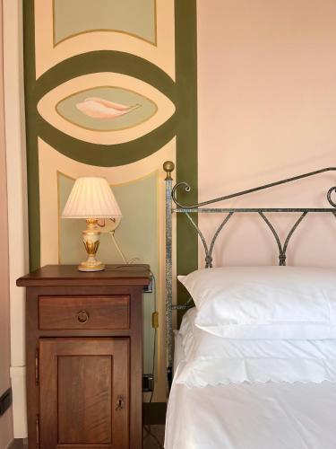 a bedroom with a bed and a table with a lamp at Belvedere Bike Hotel in Montà