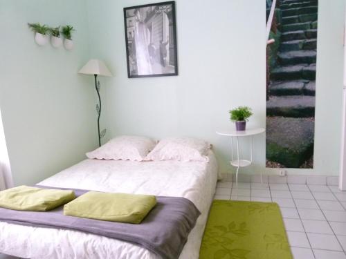 Schlafzimmer mit einem Bett mit weißer Bettwäsche und gelben Kissen in der Unterkunft Perrache Sainte Blandine in Lyon