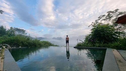 a man standing in the middle of a pool of water at Inh La Home Pu Luong in Pu Luong