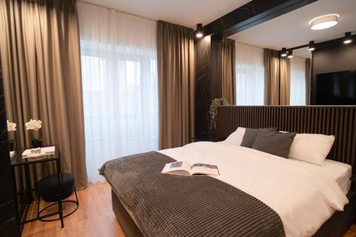 a bedroom with a large bed with two books on it at MoRent Apartments in Mostar