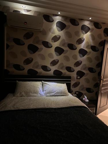 a bedroom with a bed with polka dots on the wall at Royal apartment for family rent, 6 October in 6th Of October