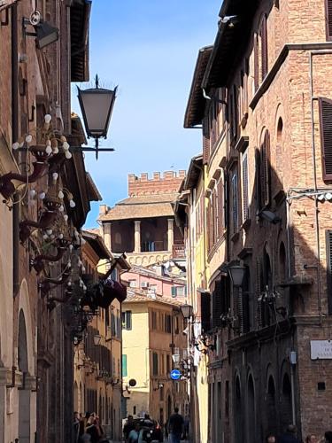 an alley with buildings and people walking down a street at Hotel Minerva in Siena
