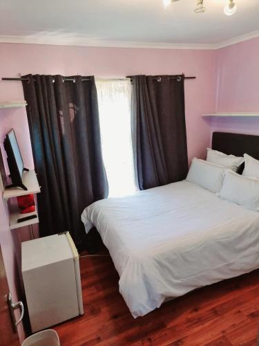 a bedroom with a white bed and a window at 3 bedroom garden house in Tableview in Table View