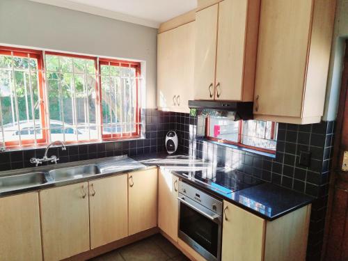 a kitchen with a sink and a stove top oven at 3 bedroom garden house in Tableview in Table View