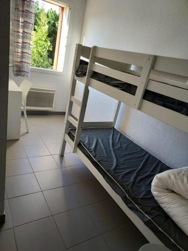Ce lit superposé se trouve dans un dortoir doté d'une fenêtre. dans l'établissement Les demeures de la massane, à Argelès-sur-Mer