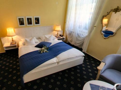 sypialnia z dużym łóżkiem i niebieskim krzesłem w obiekcie Hotel-Restaurant Drei Hasen w mieście Michelstadt