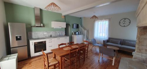 une cuisine et une salle à manger avec une table et des chaises dans l'établissement Charmante maison en pierre en Périgord 