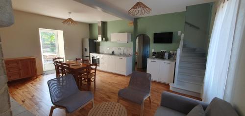 une cuisine et une salle à manger avec une table et des chaises dans l'établissement Charmante maison en pierre en Périgord 