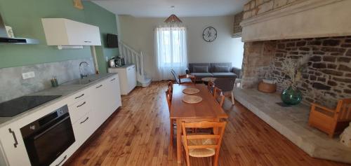 une cuisine et un salon avec une table et un canapé dans l'établissement Charmante maison en pierre en Périgord 