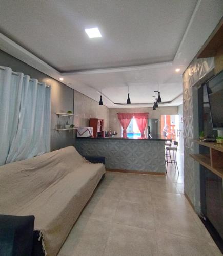 a bedroom with a bed and a kitchen in the background at POUSADA e HOTEL FLORESTA AMAZÔNICA in Nova Emprêsa