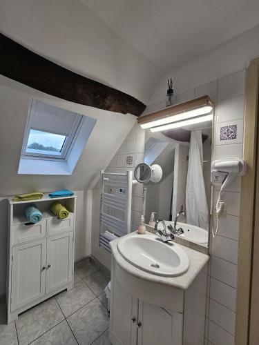 une salle de bain blanche avec un lavabo et une fenêtre dans l'établissement Le nid de l'écureuil, à Selles-sur-Cher