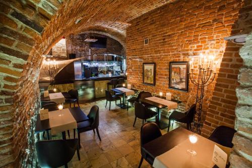 a restaurant with tables and chairs and a brick wall at Hotel Senacki in Krakow