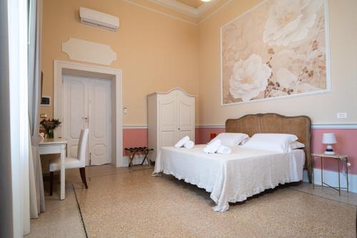 a bedroom with a bed and a desk and a painting at Antica Loggia in Vibo Valentia