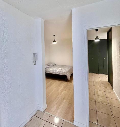 une chambre avec un lit et une chambre avec un couloir dans l'établissement Appartement T5 Spacieux, à Lyon