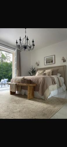 a bedroom with a large bed and a chandelier at Suite parentale in Lamorlaye