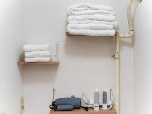 a towel rack with towels on a wall at Asakusa 4min walk, 8min to Senso-ji Temple, 5min to Ueno,4 min to Kappabashi, Switch, Free Wi-Fi, PocketWi-Fi in Tokyo