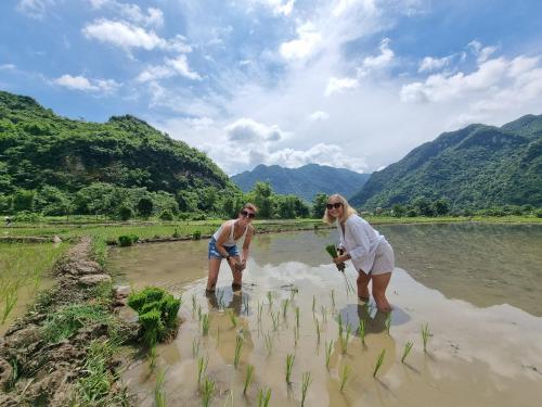 a man and a woman standing in the water at Inh La Home Pu Luong in Pu Luong