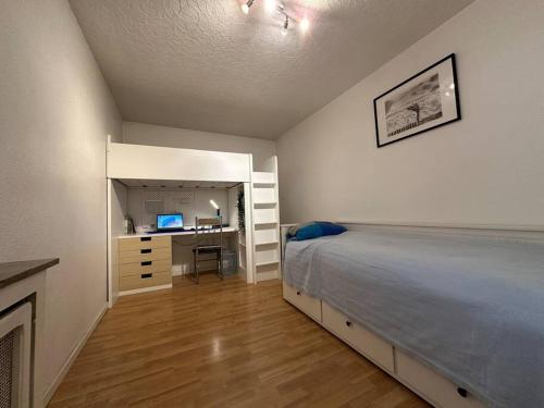 a bedroom with a bed and a desk with a computer at Top 3 Zimmer Appartment bei der Schalke Arena, Sport und Natur nähe Dortmund Essen Düsseldorf Oberhausen in Gelsenkirchen