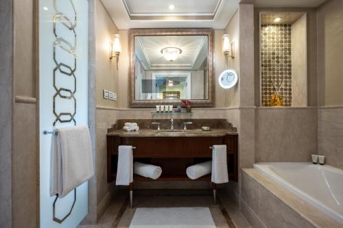 a bathroom with a sink and a tub and a mirror at Waldorf Astoria Jerusalem in Jerusalem