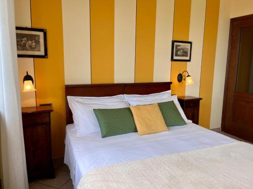 a bedroom with a bed with yellow and white stripes at Belvedere Bike Hotel in Montà