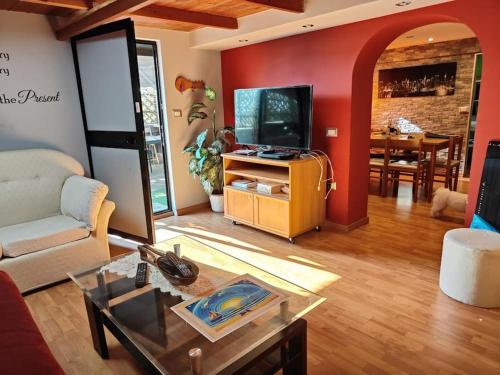 a living room with a couch a table and a tv at Casa Sandra in Pirri