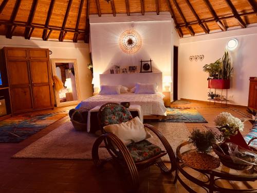 a bedroom with a bed and a table and chairs at LasNubes EcolodgeNubes Ecolodge in Santa Elena