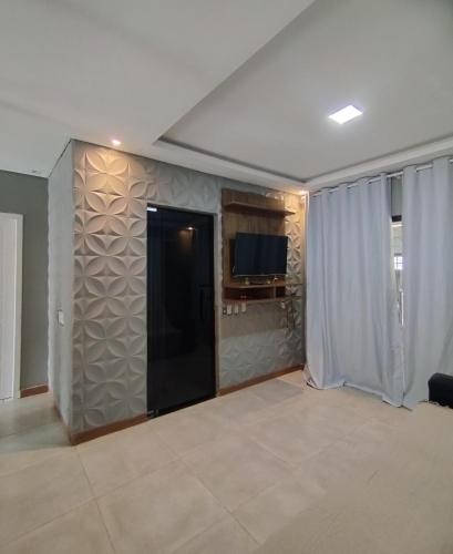 a living room with a wall with a tv and a wall at POUSADA e HOTEL FLORESTA AMAZÔNICA in Nova Emprêsa