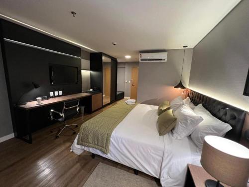 a hotel room with a large bed and a desk at QS Marista by Camilo in Goiânia