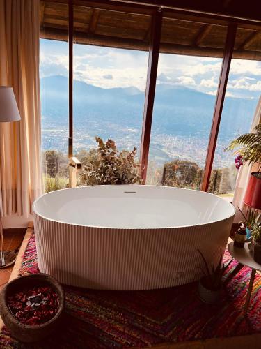 a large white bath tub in front of a large window at LasNubes EcolodgeNubes Ecolodge in Santa Elena