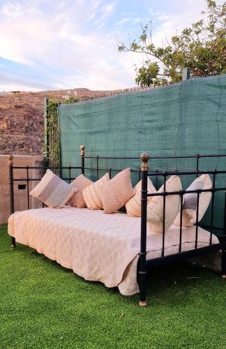 a bed with pillows sitting on the grass at Casa Joy in Tejina de Isora