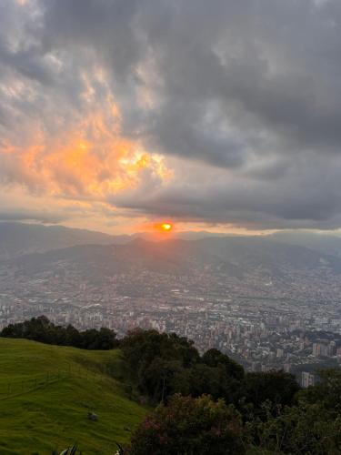 a view of a city from a hill at sunset at LasNubes EcolodgeNubes Ecolodge in Santa Elena