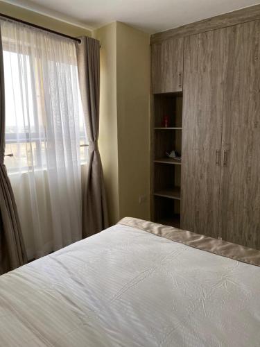 a bedroom with a large bed and a window at Kajiado Homes 2 in Kajiado