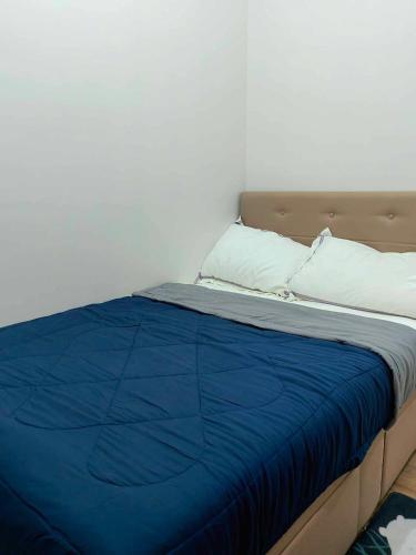 a bed with a blue blanket and two pillows at Vian'z Condotel in Naga