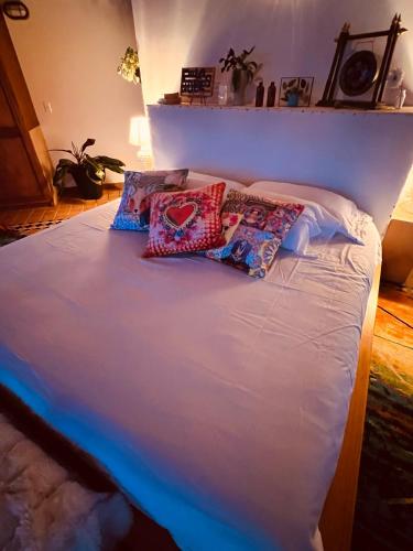a bed with pillows on top of it at LasNubes EcolodgeNubes Ecolodge in Santa Elena