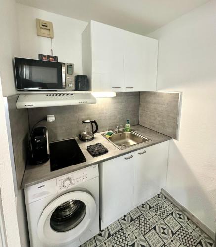 Il comprend une petite cuisine équipée d'un lave-linge et d'un four micro-ondes. dans l'établissement Studio Gare entièrement Rénové, Wi-Fi, Clim, Tram, 15 min des Plages, à Montpellier