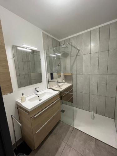 a bathroom with two sinks and a glass shower at Gites de Landuzière in Étrat