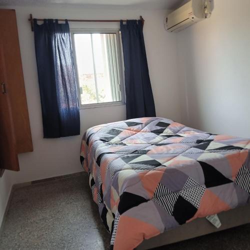a bedroom with a bed and a window at Apartamento duplex único en Carmelo in Carmelo