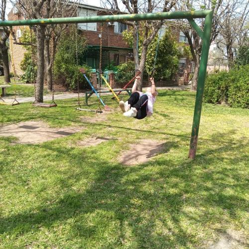two people playing on a swing set in a park at Apartamento duplex único en Carmelo in Carmelo