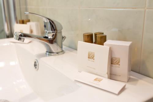 a bathroom sink with two boxes and a faucet at Harmonie House in Verona