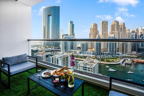 a balcony with a table and a view of a city at Elite Waterfront 3BR Haven - Marina and Sea Views! in Dubai